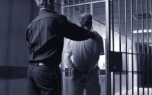 Man led through cell door.