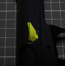 A fragment from a magneto-optical sensor, originally developed for medical purposes, reveals an obliterated serial number on a gun when viewed through a polarized filter