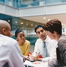 A diverse group of four people sitting around a table.