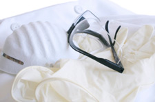Photo of a lab coat, breathing mask, safety glasses, and rubber gloves