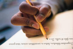 Photo of hand holding pencil over paper