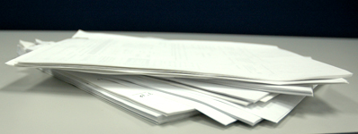 Image of paper documentation stacked on a table