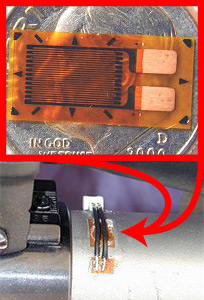 Size comparison of a strain gauge mounted on a rifle and a dime