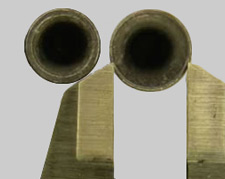 Deep hollow-based lead bullets, held by calipers.