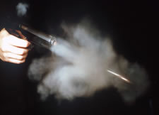 Pistol firing showing residue from muzzle and ejection port