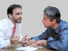 Two men talking while examining a document