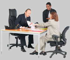 Two men and a woman examining a document at a table