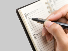 A hand writing in a day planner