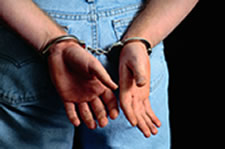 Photo of an arrestee behind handcuffs