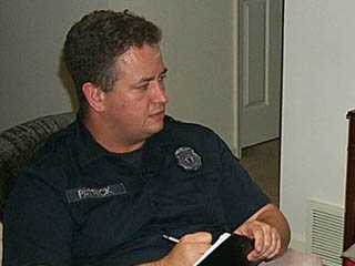 Photo of Officer Harris receiving a call to take a report of a burglary. 