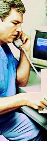 Man at a hospital in scrubs on the telephone
