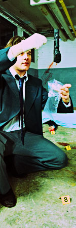 Detective holding up a gun at a crime scene