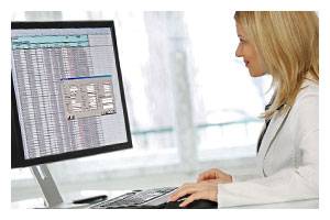 Photo of a woman in a lab coat looking at a computer