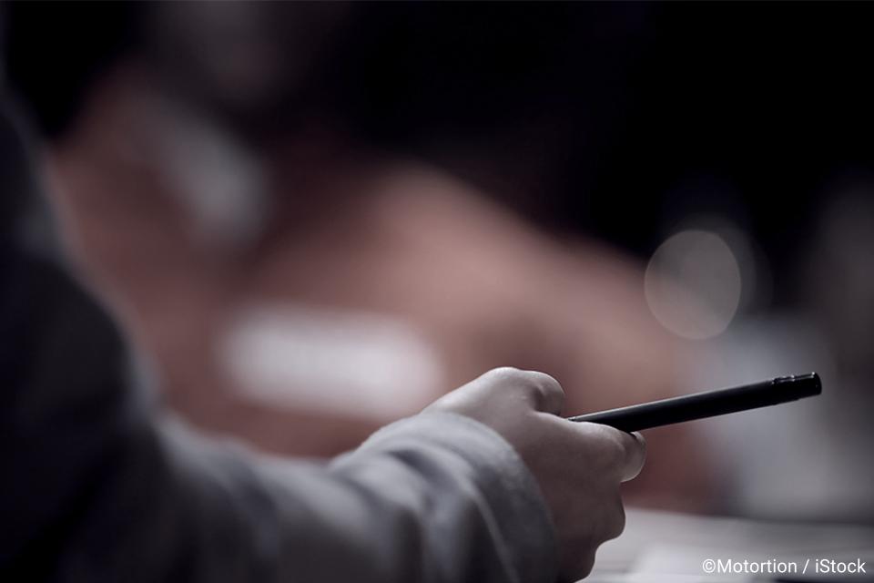 Person holding a pen at an event.