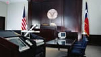 Photo of an empty courtroom with a testifying stand
