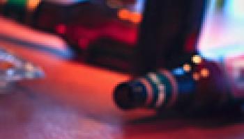 Picture of a set of keys and an empty alcohol bottle at a bar in a crime scene